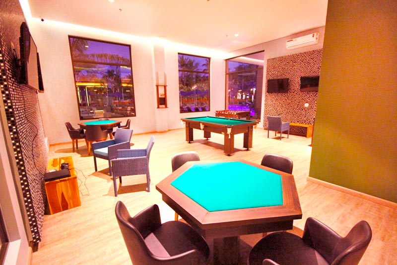 Sala de jogos com detalhes de sinuca e mesa para poker